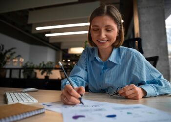 Mulher sorrindo enquanto organiza suas contas.