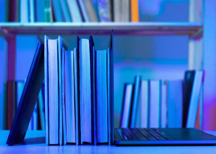 Prateleira com vários livros e um notebook