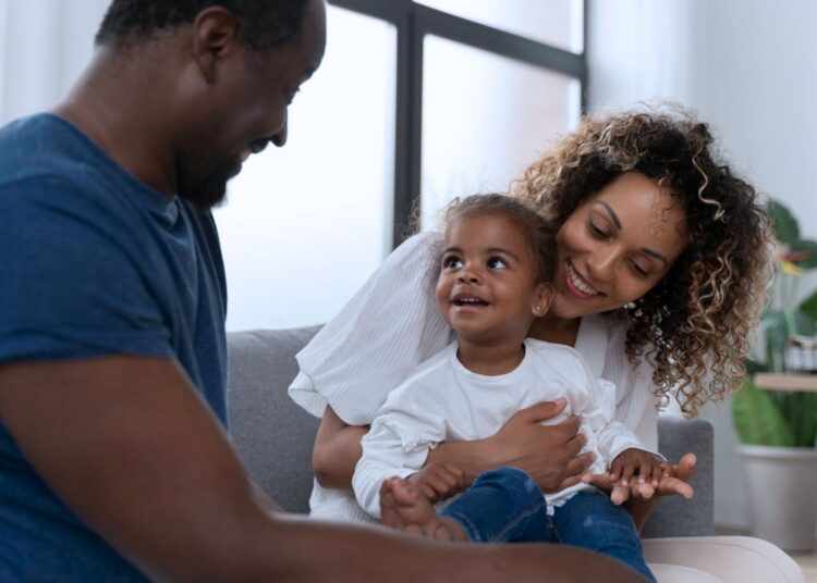 Casal brincando com a sua filha pequena.