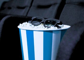 Balde de pipoca azul e branco com um óculos em cima.