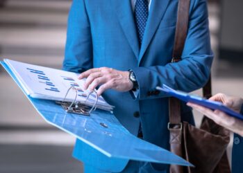 Homem segurando um relatório com gráficos impressos.