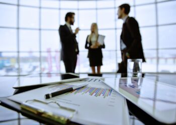 Dois homens e uma mulher conversando no escritório.