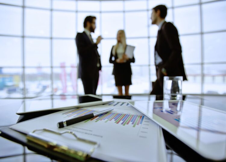 Dois homens e uma mulher conversando no escritório.