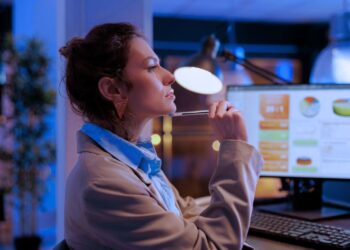 Mulher analisando dados e indicadores no computador.