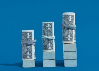 Três “bolos” de dinheiro simulando um gráfico crescente.