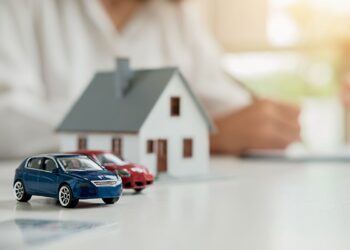 Miniaturas de carros e casa simbolizando bens usados como garantia em contratos de alienação fiduciária.
