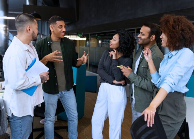 Grupo de profissionais em ambiente corporativo discutindo ideias e colaborando, representando os valores de uma empresa, como inovação, trabalho em equipe e diversidade.