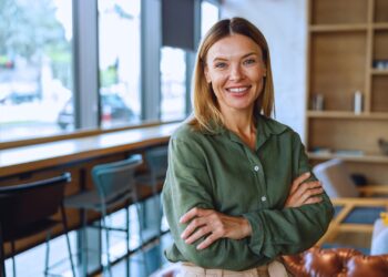 Empresária sorridente em ambiente corporativo moderno, representando segurança e confiança no processo de empréstimo PJ sem garantia.
