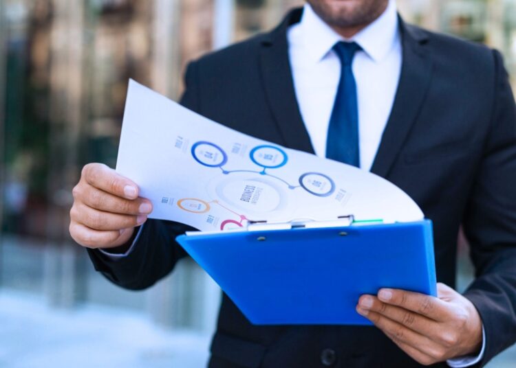 Profissional analisa estrutura tributária e documentos sobre o que é bitributação no Brasil.